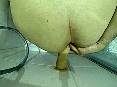 a big slave gets roughly fucked with bloody dildo in shower