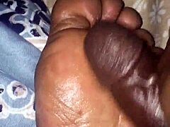 girlfriend gives footjob to boyfriend in bedroom, teasing with feet and hands.
