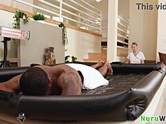 Gorgeous blonde masseuse with big boobs gives wet nuru massage naked to black client!