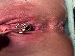 Why is this pierced clit getting rubbed hard in latex gloves before a strong pee stream?