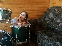 Watch this petite brunette teen fuck her tight pussy deep with a huge dildo right on the drumset